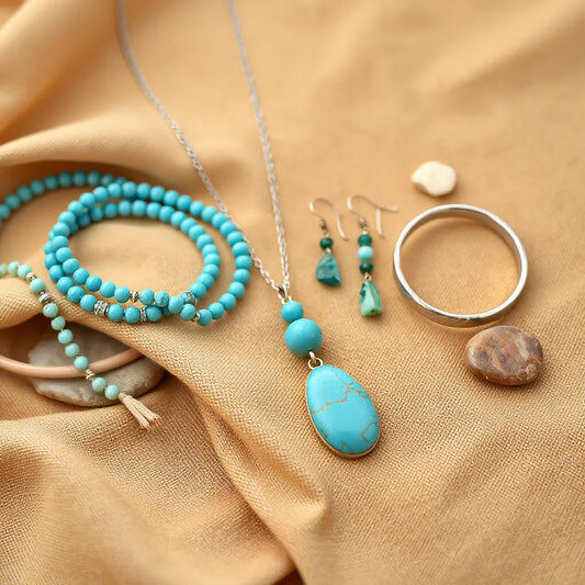 Turquoise pendant necklace and stacked bohemian southwestern jewelry on desert-toned fabric with soft natural stones
