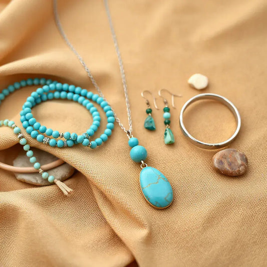 Turquoise pendant necklace and stacked bohemian southwestern jewelry on desert-toned fabric with soft natural stones