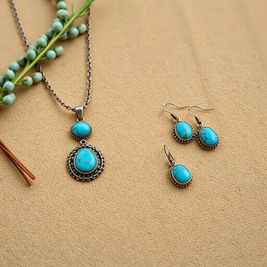 Turquoise pendant necklace and earrings on desert-toned fabric with subtle silver accents