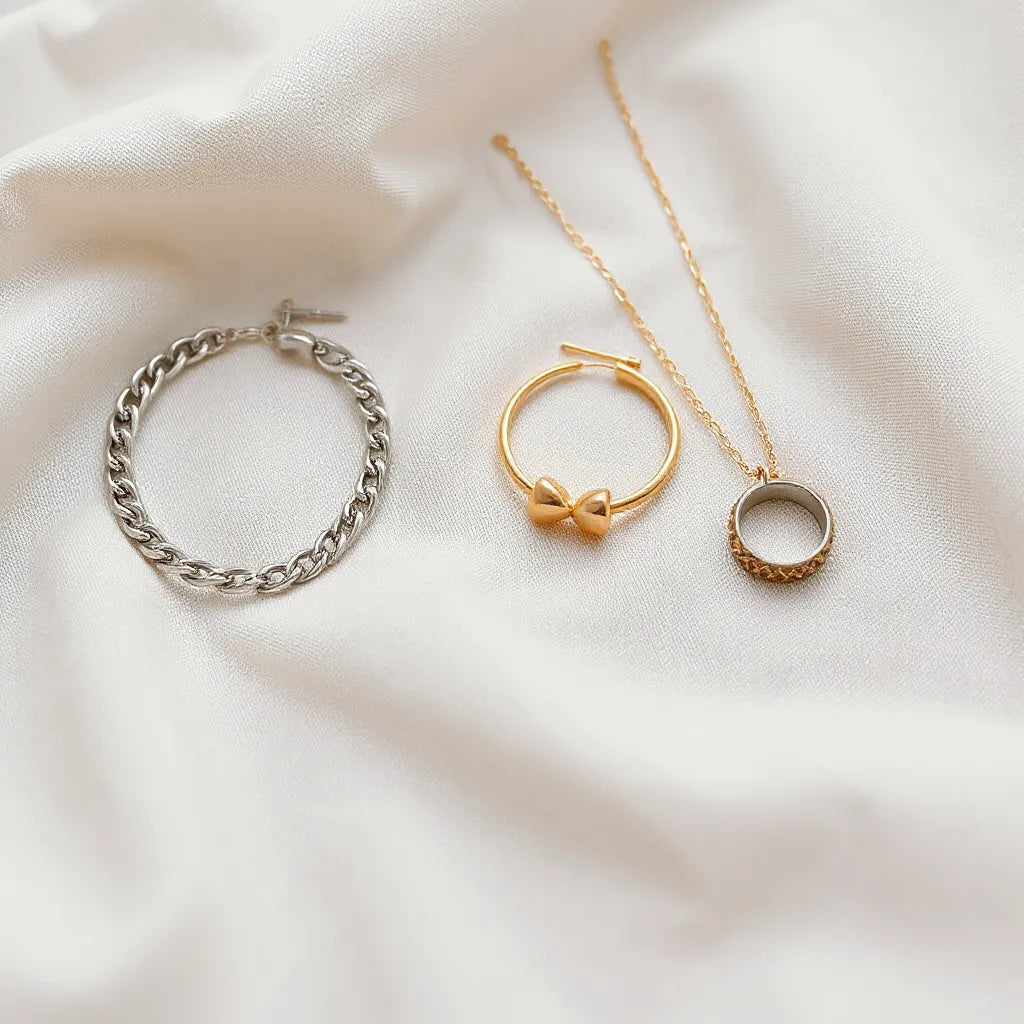 Silver and gold jewelry pieces arranged on neutral fabric with soft natural light