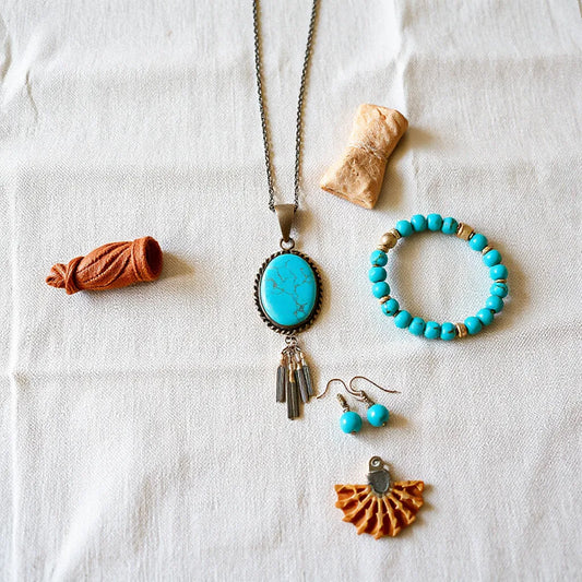 Turquoise bohemian southwestern jewelry set with necklace, earrings, and bracelets on neutral fabric
