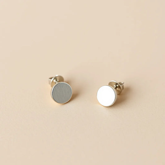 Pair of hypoallergenic earrings with visible ear-safe metal posts on a neutral studio background