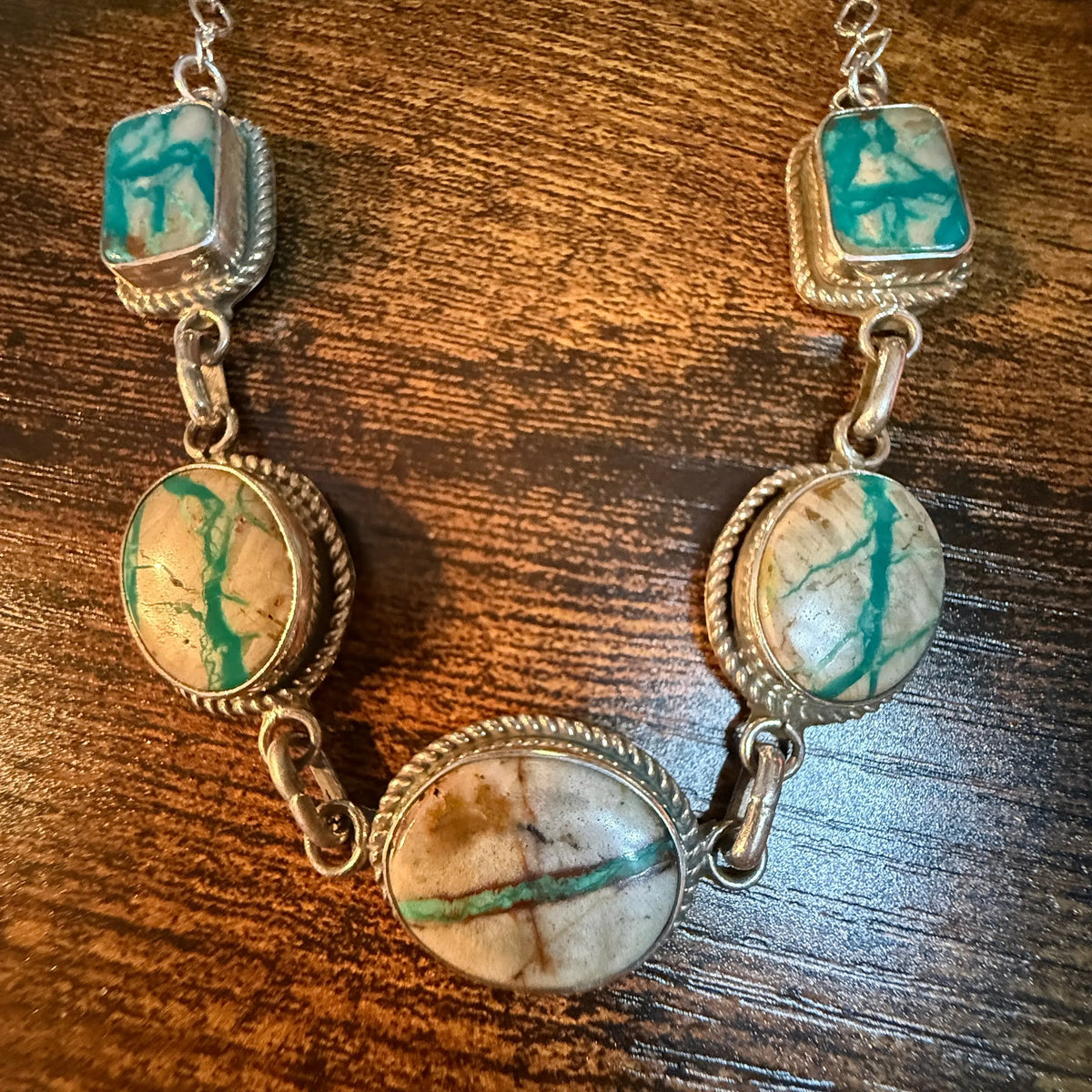Boho turquoise sterling silver choker necklace featuring earthy oval and square stones with rope-textured silver settings in a Native American-inspired design.
